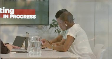 Ofiste, çeşitli takımlar proje üzerinde çalışıyor, toplantı odasında fikirleri tartışıyorlar. İşbirliği, takım çalışması, iş, beyin fırtınası, yenilik, çeşitlilik