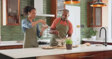 Modern mutfakta birlikte yemek pişiren, eğlenen ve evde yemek hazırlayan farklı çiftler. Mutfak, yerli, yaşam tarzı, gurme, hazırlık, etkileşim