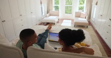 Evde dinlenen, çeşitli çiftler dizüstü bilgisayar ve kitap ile boş vakitlerin tadını çıkarıyorlar. Rahatlama, rahatlık, teknoloji, yaşam tarzı, birliktelik, bağlanma