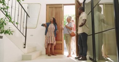 Ev girişinde sıcak bir karşılama, çok nesilli çeşitli aile kucaklaşmaları ve gülümsemeleri paylaşıyor. Beraberlik, yakınlaşma, kutlama, duygusal, aşk, birleşme