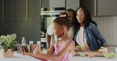 Çeşitli aileler mutfakta eğleniyor, gülümsüyor ve akıllı telefonlara bakıyor. Bağlanma, birliktelik, teknoloji, yaşam tarzı