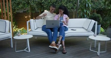 Çeşitli çiftler verandada rahatlıyor, dizüstü bilgisayar kullanıyor ve birlikte gülüyorlar. Aşk, eğlence, yaşam tarzı, bağlanma, ilişki, teknoloji