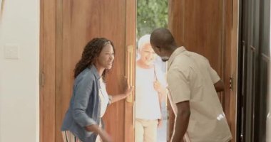 Çeşitli aile üyeleri evde toplanıyor, gülümsüyor ve ön kapıda sıcacık kucaklaşıyorlar. Beraberlik, kutlama, mutluluk, kaynaşma