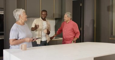 Modern mutfakta kutlama yapan, çeşitli aileler üç nesil boyunca evlerinde neşeli kucaklaşmalar yapıyorlar. Kutlama, mutluluk, çok nesilli, birliktelik, birlik, yaşam tarzı