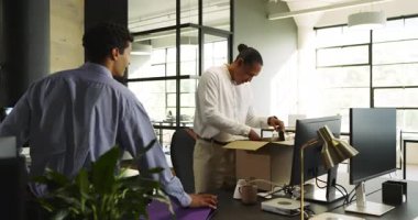 Ofisteki işadamı bilgisayar ve kutuların yanındaki meslektaşıyla proje tartışıyor. İşbirliği, takım çalışması, çalışma alanı, şirket, profesyonel, üretkenlik