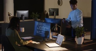 Çeşitli meslektaşlar ofis masasında bilgisayar ekranları ve belgelerle projeyi tartışıyor. İş, takım çalışması, işbirliği, şirket, beyin fırtınası, toplantı