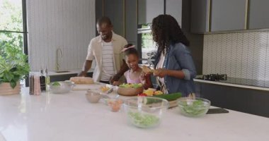 Çeşitli aileler modern mutfakta sağlıklı salata hazırlıyor, kaliteli zaman geçiriyorlar. Yemek pişirme, birliktelik, bağ kurma, sağlıklı beslenme.