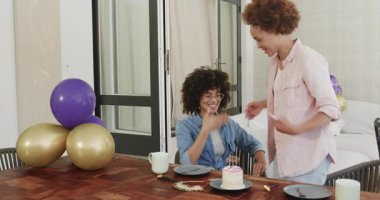 Doğum gününü kutluyoruz, çeşitli lezbiyen çiftler evde pasta ve balonlarla el çırpıyor ve gülümsüyor. Kutlama, parti, mutluluk, yıldönümü, aşk, ilişki