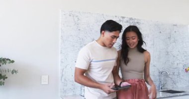 Çeşitli çiftler mutfaktaki mermer tezgaha doğru bakıyorlar, tablet ve krom muslukla. Çağdaş, zarafet, yaşam tarzı, iç mekan, minimalizm, refah, bağlantı