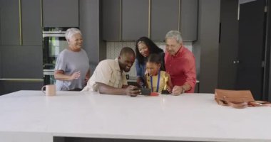 Çeşitli aileler genç kızın başarısını madalya ve hediyeyle modern mutfakta kutluyorlar. Kutlama, ödül, mutlu, gururlu, destek, birliktelik