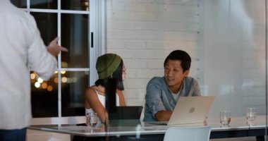 Dizüstü bilgisayarlarda işbirliği yapmak, çeşitli takımlar gece yarısı ofis toplantılarında proje fikirlerini tartışmak. Takım çalışması, beyin fırtınası, teknoloji, işbirliği, iş toplantısı, verimlilik