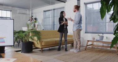 Asyalı kadın ve beyaz adam modern ofiste tablet üzerinde çalışıyorlar. İş, takım çalışması, işbirliği, teknoloji, şirket, iş arkadaşları