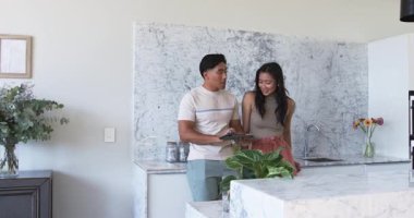 Değişik görünüşlü çift modern mutfakta mermer arka sıçramaya hayran, tabletli, kopyalama alanlı. Çağdaş, yaşam tarzı, iç mekan, zarafet, minimalizm, bağlantı, uyum