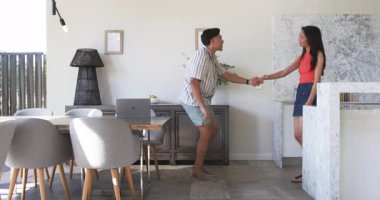 Modern mutfak ve yemek alanında dizüstü bilgisayar ve bir kase muzla dans eden çift. Yaşam tarzı, koreografi, canlılık, çağdaş, iç mekan, mutluluk, kutlama