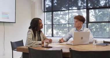 Çeşitli meslektaşlar ofis masasında dizüstü bilgisayar ve belgelerle projeyi tartışıyor. İşbirliği, takım çalışması, iş toplantısı, beyin fırtınası, şirket, profesyonel