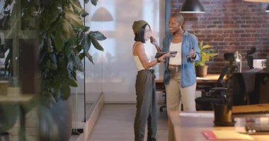 Modern ofiste, iki kadın el sıkışıyor ve iş stratejilerini tartışıyorlar. Ortaklık, işbirliği, takım çalışması, profesyonel, müzakere, anlaşma