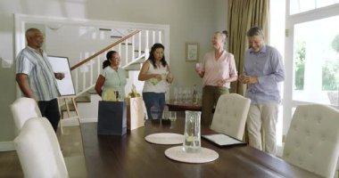 Üst düzey çeşitli arkadaşlar evde kutlama yapıyor, içki içiyor ve yemek masasının etrafında sohbet ediyorlar. Kutlama, şenlik, toplanma, yemek, neşe, birliktelik