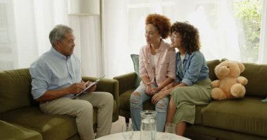 Evdeki kanepede aynı cinsiyetten sırıtan lezbiyen çiftlerle konuşan yaşlı bir adam. danışmanlık, tavsiye, çeşitlilik, sohbet, yaşam tarzı, ilişki