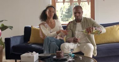 Çeşitli çiftler evde kutlama yapıyor, şarap içiyor ve kanepeye pasta yiyorlar. Kutlama, tatlı, rahatlama, konfor, yaşam tarzı, birliktelik