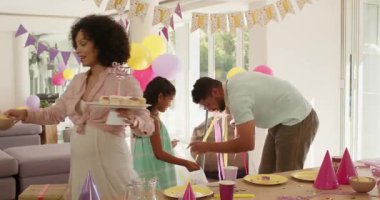 Doğum günü partisinden sonra evde balonlar ve dekorasyonlarla çeşitli aileler temizlik yapıyor. Kutlama, takım çalışması, ev işi, derleme, yaşam tarzı