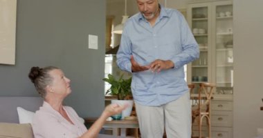 Evde dizüstü bilgisayar kullanan çeşitli çiftler, birlikte online göreve odaklanıyorlar. Teknoloji, takım çalışması, işbirliği, ortaklık, konsantrasyon, yerli