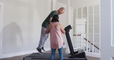 Son sınıf öğrencisi koşu bandında koşarken genç kız destek olarak alkışlıyor, boşluğu kopyalıyor. Egzersiz, spor, sağlık, teşvik, aile, eğitim