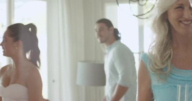 Çeşitli aile üyeleri ve arkadaşları evlerinde şampanya kadehleriyle kadeh kaldırırken. Kutlama, konukseverlik, sofistike, zarafet, sıcaklık, arkadaşlık, yaşam tarzı