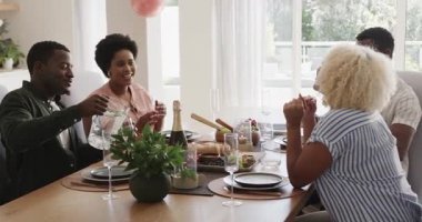 Arkadaşlar evde öğle yemeğinin tadını çıkarıyor, gülüşmeler ve sohbetler. Arkadaşlık, toplanma, yemek, birliktelik, kaynaşma, yemek