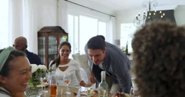 Yaşlı bir kadın el kol hareketi yapıyor, kadeh kaldıran bir çift yemek masasında kutlama yapıyor. Kutlama, neşe, arkadaşlık, zarafet, toplanma, neşe, merasim