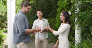 Bahçe yolunda yüzüklerini değiş tokuş eden çift nikah kıyılmış ve konuklar alkışlıyor. Romantizm, kutlama, bağlantı, zarafet, açık hava, neşe, birlik