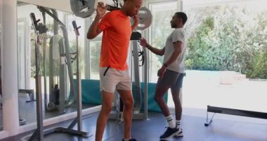 Spor salonunda antrenmandan sonra dinlenen Afrikalı Amerikalı bir adam, bitkin görünüyor. Fitness, egzersiz, iyileşme, sağlık, sağlık, eğitim