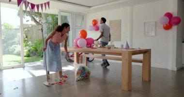 Çeşitli çiftler evlerinde konfeti ve ikramla dekor düzenliyor ve balon asıyorlar. Kutlama, parti, dekorasyon, şenlik, renkli, neşeli, toplanma, etkinlik