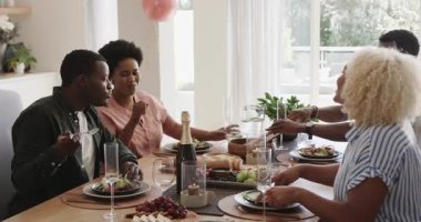 Öğle yemeğini ve kahkahaları paylaşmak, farklı arkadaşların evde sohbet etmesi. Bağ, mutluluk, yaşam tarzı, çeşitlilik, yemek, birliktelik