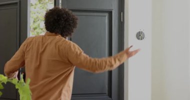 Girişteki adam dışarıda arkadaşlarını görüyor, ön kapıyı açıyor, ziyaretçiye sarılıyor ve onu içeri sokuyor. Hoşgeldin, dostluk, toplum, selamlama, bağlantı, gündelik, ev