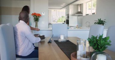 Yemek masasında okumak, Afro-Amerikan baba, oğul, anne çeşitliliği evde kahvaltı hazırlamak. aile, ebeveynlik, bağlılık, yaşam tarzı, yerli, sabah