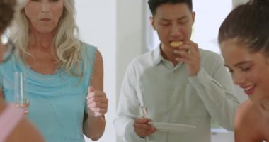 Çeşitli arkadaşlar abur cubur tadıyor, mutfak adasında şampanya kadehi kaldıran yaşlı bir kadın olarak sohbet ediyorlar. Kutlama, yoldaşlık, sosyal toplanma, yaşam tarzı, modern, canlı, mutluluk