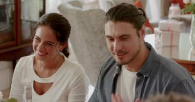 Kamera önünde selamlaşmayı duyduktan sonra bir çift yemek masasında şarap kadehleri tokuşturup gülüyor. Romantik, kutlama, mahremiyet, neşe, samimiyet, neşe, mutluluk