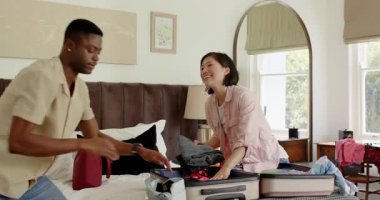 Çeşitli çiftler, seyahat çantalarını aldıktan sonra kıyafetlerini bavula koyup katlıyorlar. Seyahat, paketleme, organizasyon, yerli, yaşam tarzı, samimi, samimi