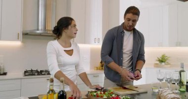Mutfak adasında salata için biber ve soğan doğrayan, kaseye karıştıran ve kucaklayan bir çift. Romantizm, samimiyet, ev yemeği, aşçılık, birliktelik, modern, yaşam tarzı
