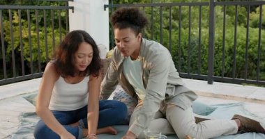 Şakacı sohbet sırasında adam teras pikniğinde Asyalı kadının çenesine çilek suyu sürüyor. Romantizm, boş zaman, mahremiyet, açık hava, canlı, samimi, bağlantı