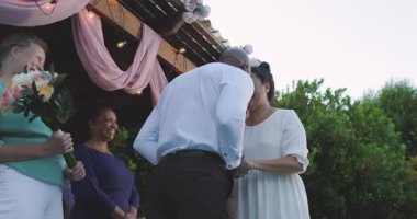 Düğünde, kadın bahçede çeşitli son sınıf arkadaşlarıyla kutlama yapıyor, neşeyle dans ediyor ve alkışlıyor. Kutlama, yaşlı yetişkin, mutluluk, birliktelik, yaşam tarzı