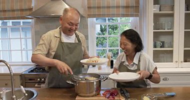 Birlikte yemek pişirmek, mutfakta yemek hazırlamak, evde neşeli anlar paylaşmak. Mutluluk, yaşlılık, aşk, evcil, yemek, hazırlık