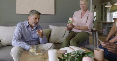 Çiçekler ve kartlarla kutlama, farklı yaşlılar evde sohbet ve kahkaha paylaşıyor. Kutlama, dostluk, mutluluk, neşe, ilişki, bağ