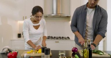 Mutfak adasında biber doğrayan, salatalık kesen, sarılan ve salata yapan çiftler. Romantik, takım çalışması, aşçılık, modern, yaşam tarzı, taze, canlı