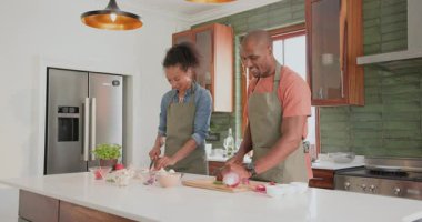 Modern mutfakta, evde, birlikte yemek hazırlarken çeşitli çiftler neşeyle dans ediyor. Yemek pişirme, ilişki, mutluluk, yaşam tarzı, ev hayatı, yemek hazırlama