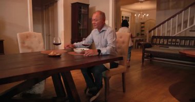 Kıdemli kadın evde şarap ve salata ile yemek masası hazırlıyor. Yemek, sofra kurma, olgun, yaşam tarzı, hazırlık.