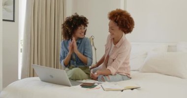 Evde dizüstü bilgisayar kullanırken gülümseyen eş cinsiyetli lezbiyen çift. LGBTQ, aşk, teknoloji, yerli, ilişki, bağ