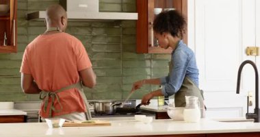 Birlikte yemek pişiren, çeşitli çiftler mutfakta ve evde taze malzemelerle lezzetli yemekler hazırlıyorlar. Takım çalışması, yemek hazırlama, sağlıklı beslenme, aşçılık, yaşam tarzı