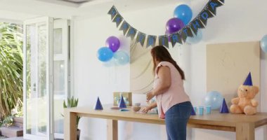 Çeşitli aileler evde doğum günü kutluyor, balonlarla ve dekorasyonlarla neşeyle dans ediyorlar. Kutlama, şenlik, parti, dans, mutluluk, birliktelik