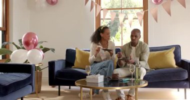 Çeşitli çiftler evde kutlama yapıyor, içkilerle kadeh kaldırıyor, pasta ve süslemelerle eğleniyorlar. Kutlama, parti, mutluluk, birliktelik